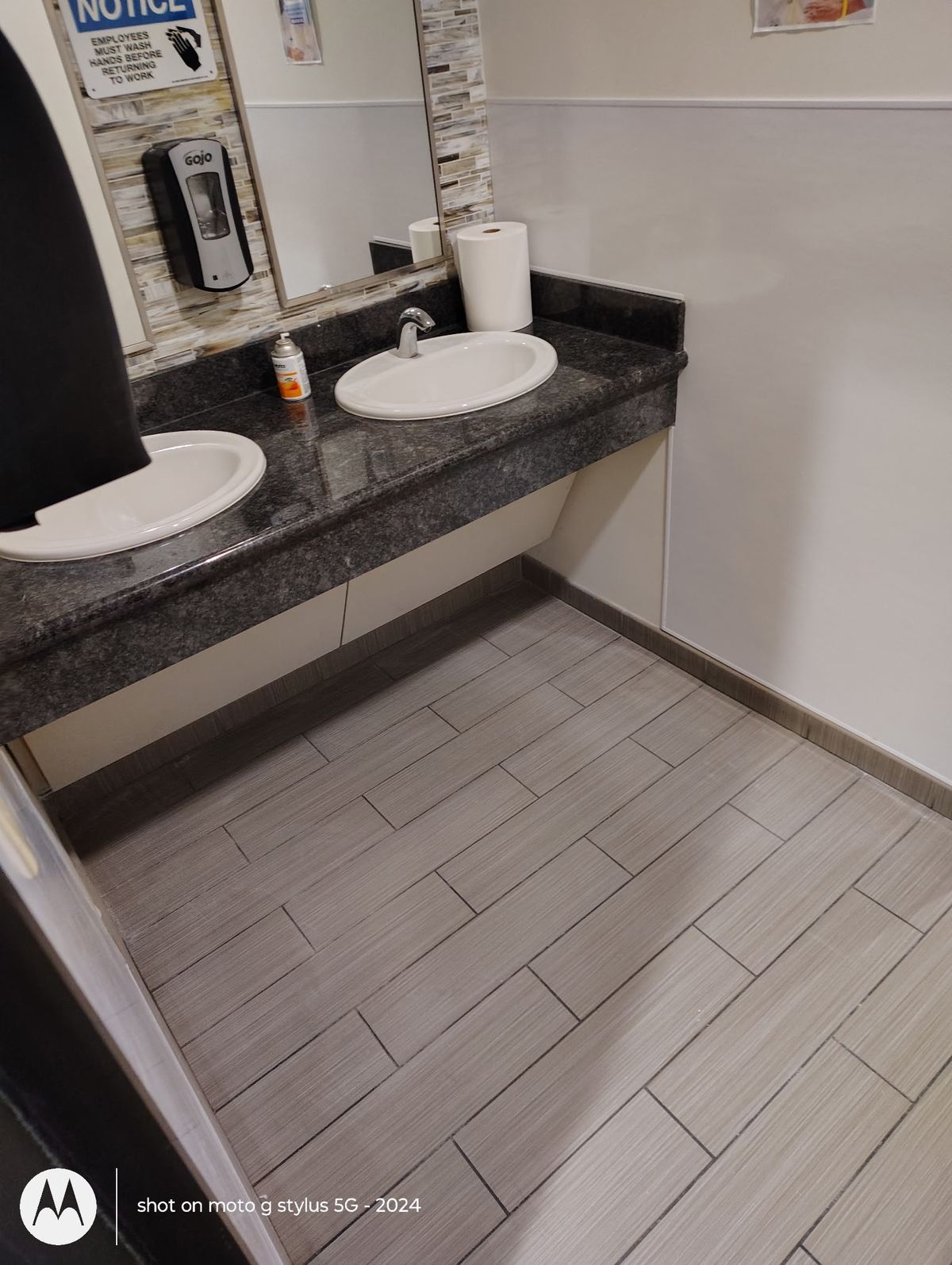 Finished commercial bathroom with granite counter and new wood-look tile floor
